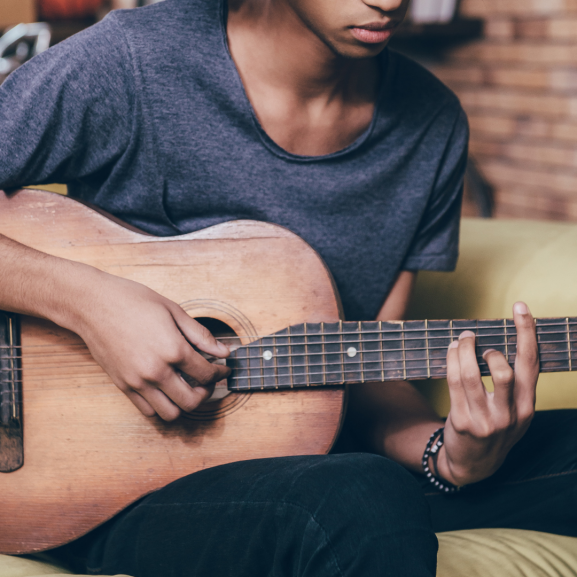Young man from eastern Africa playing guitar 