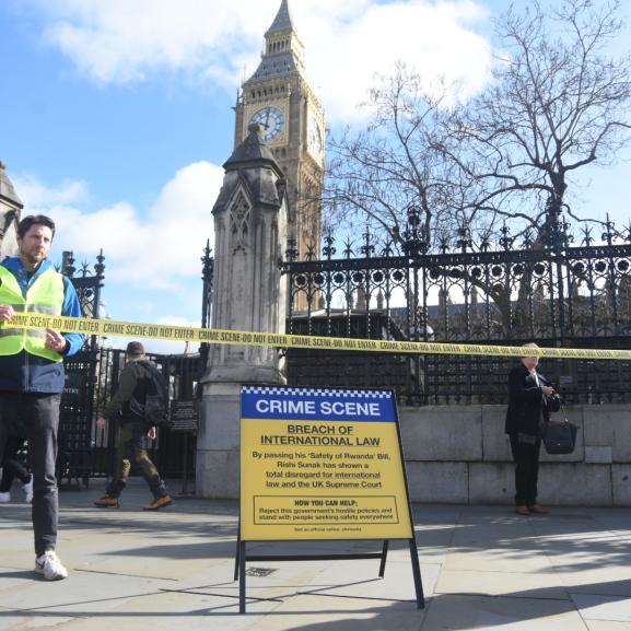 Two peope in Hi-Vis hold 'Crime scene' tape in front of a 'Crime scene' sign outside Parliament