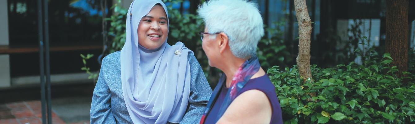 Muslim woman talking to older woman