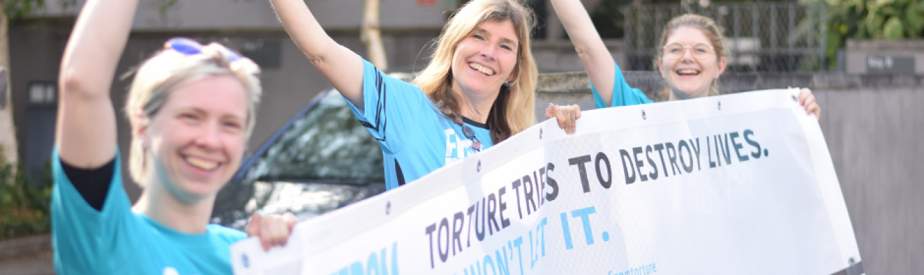 Freedom from Torture staff holding banner