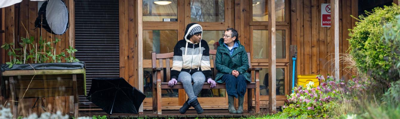 Two women sitting outdoor on a bench