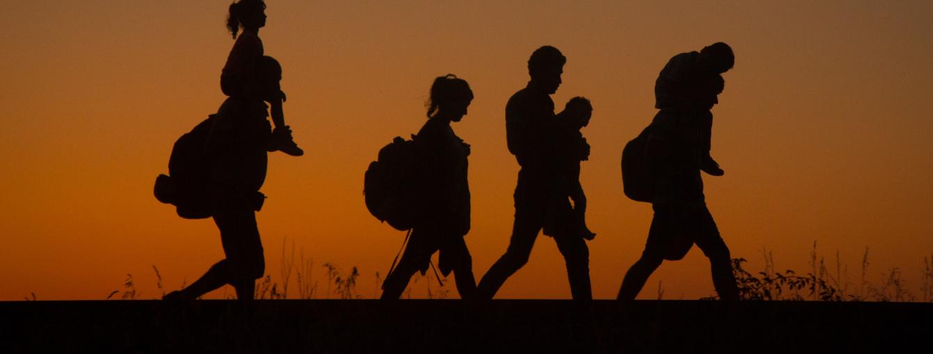 Silhouttes of a family walking, sunset in background
