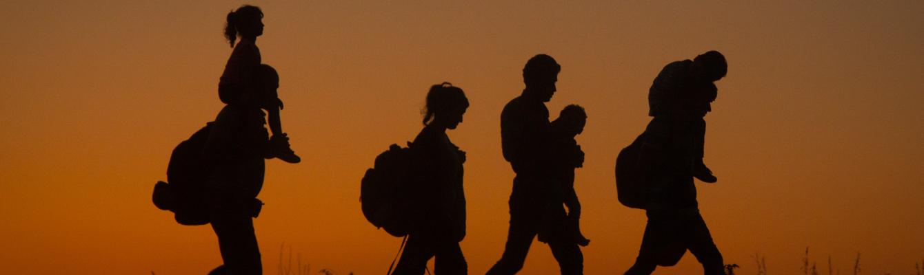 Silhouttes of a family walking, sunset in background