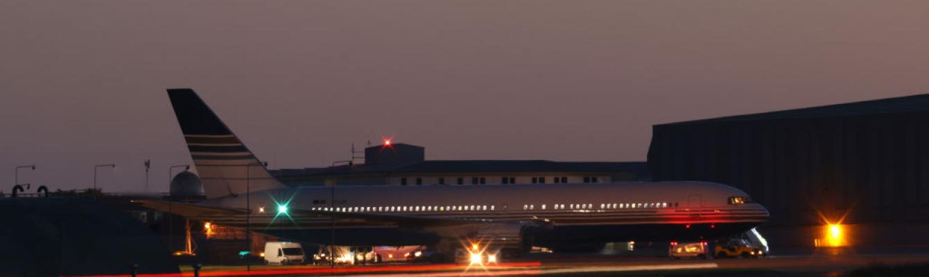 A plane on a runway, in the nighttime