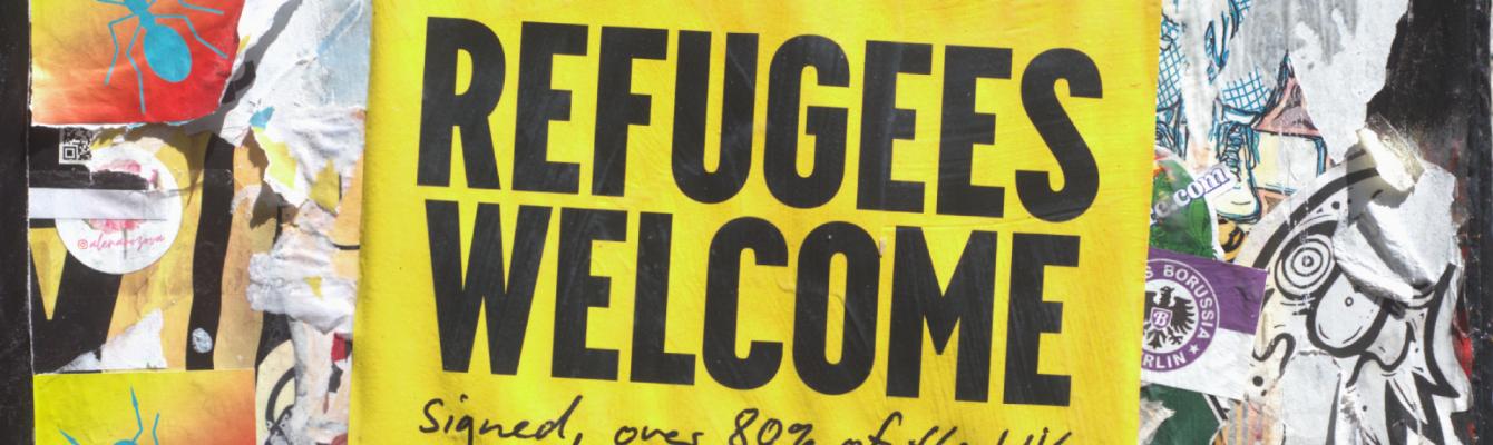 Poster on a wall that says 'Refugees Welcome'