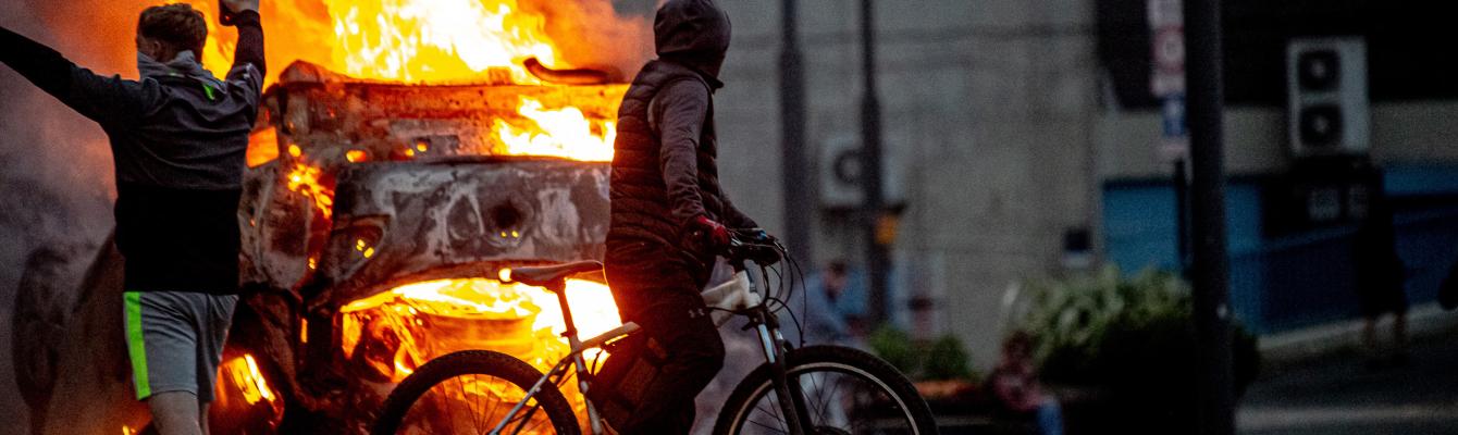 A police car is set on fire as Far-right activists riot