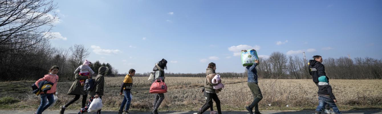 Group of people walking, carrying belongings