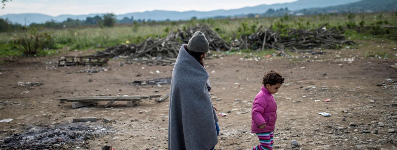Woman and child walking along dry land