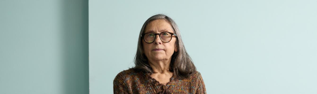 Older woman smiling at camera while sitting down
