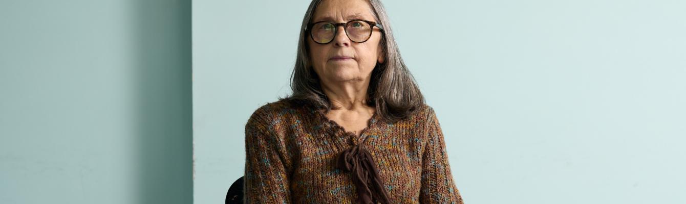 Older woman smiling at camera while sitting down