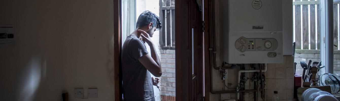 A you man stands in the doorway of his accommodation