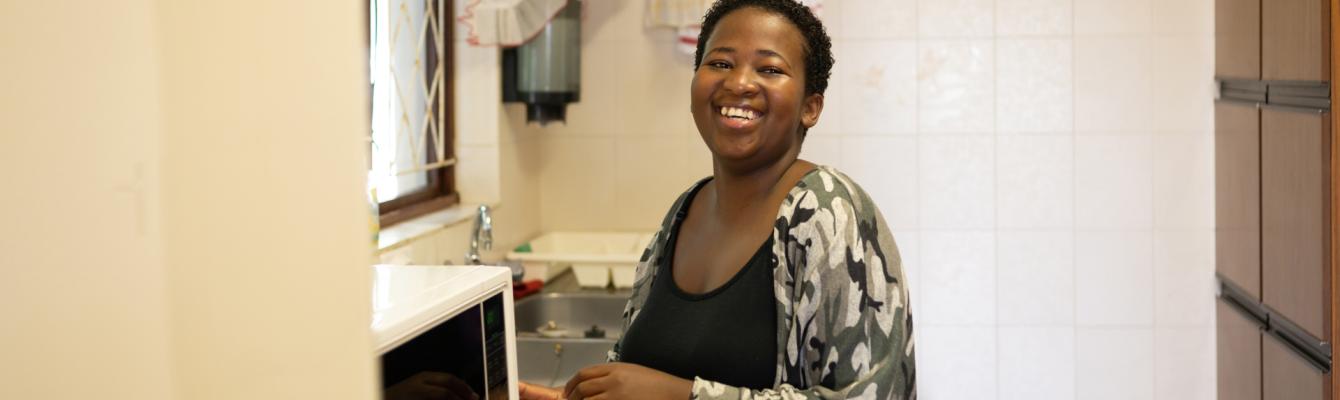 Woman in kitchen smiling at camera