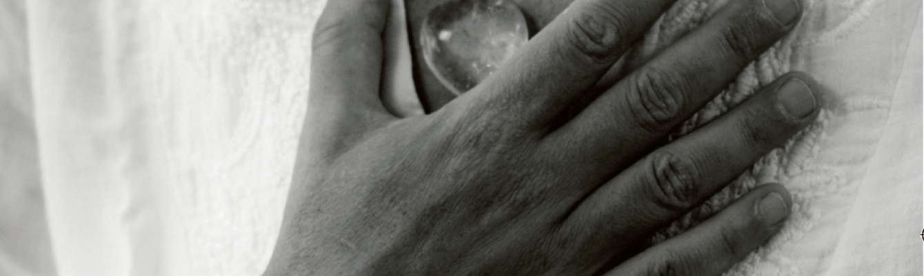 Black and white image of hand open over chest 