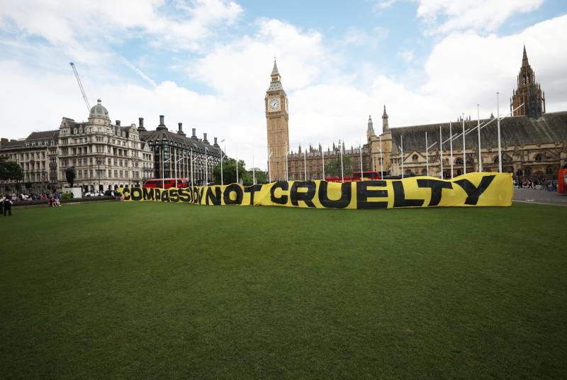 Banner on Parliament Square reading 'Compassion not cruelty'