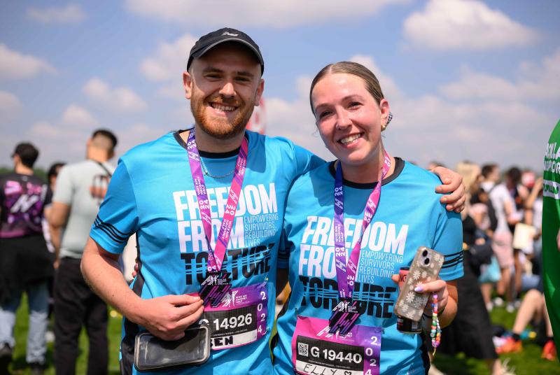 Ben and Elly standing and smiling with marathon medals