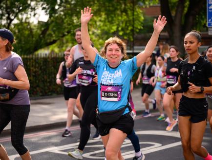 Woman running while waving her arms at the camera