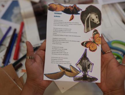 Person holding a zine showing a poem