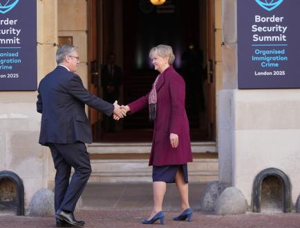 Starmer shakes hands with Cooper outside the Immigration Summit