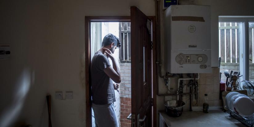 A you man stands in the doorway of his accommodation