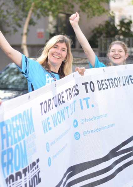 Freedom from Torture staff holding banner