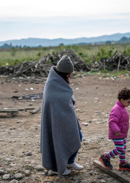 Woman and child walking along dry land