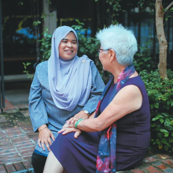 Muslim woman talking to older woman