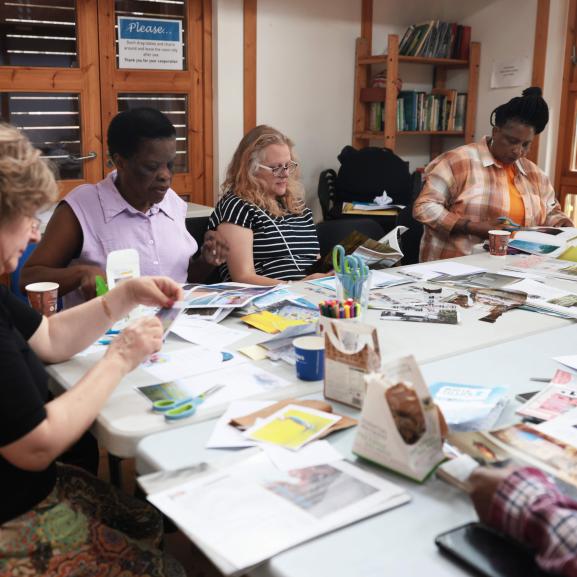 Group of people making artwork around a table