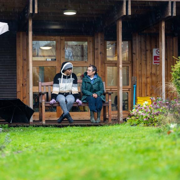 Two women sitting outdoor on a bench