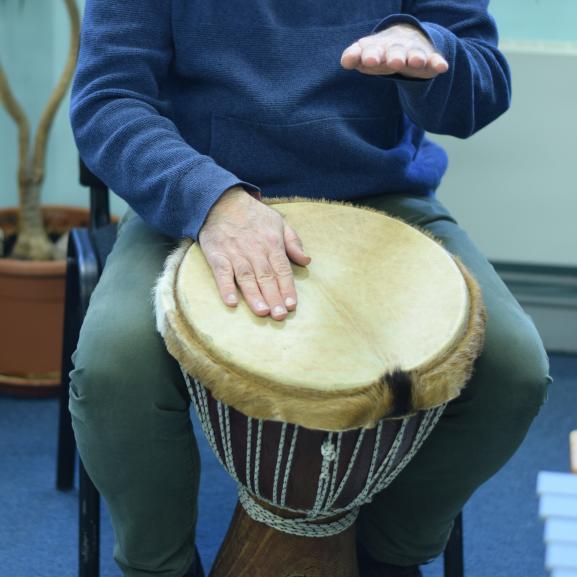 An undidentifiable person playing African drums