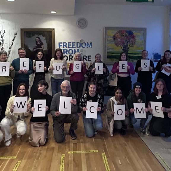 Group of people holding signs that reads 'Refugees Welcome'