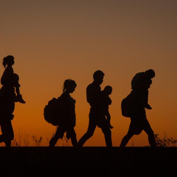 Silhouttes of a family walking, sunset in background