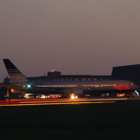 A plane on a runway, in the nighttime