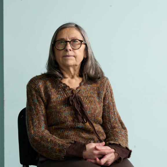 Older woman smiling at camera while sitting down