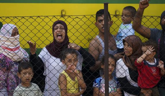 Syrian women and children refugees striking at the platform of a budapest railway station