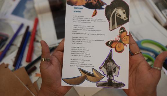 Person holding a zine showing a poem