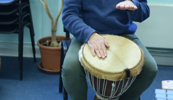 An undidentifiable person playing African drums