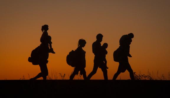 Silhouttes of a family walking, sunset in background