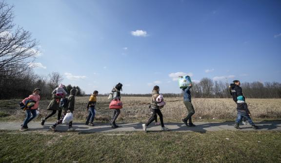 Group of people walking, carrying belongings