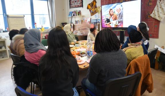 Women sitting around a table, faces concealed