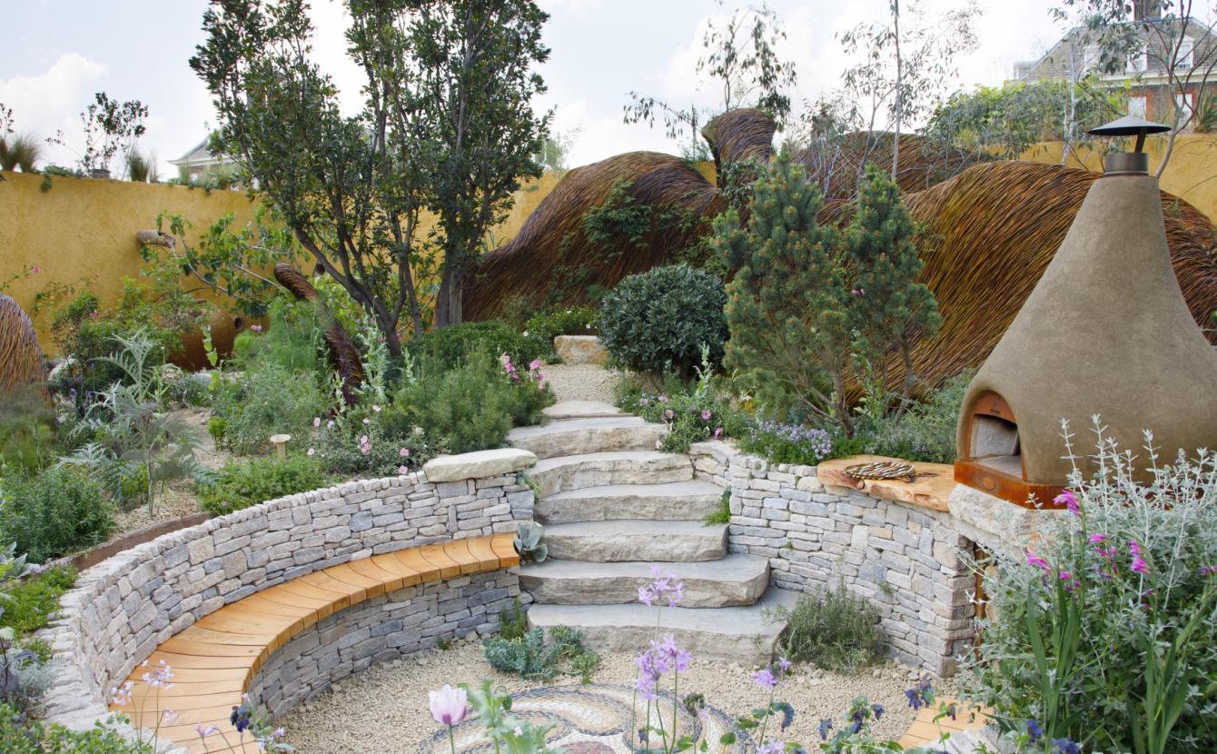 Landscape photo of our garden at Chelsea, with a bread oven and seating area